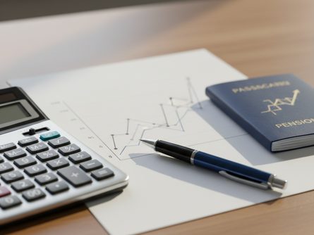 책상 위에 놓인 그래프가 그려진 종이, 계산기, 연금 통장, 파란색 펜